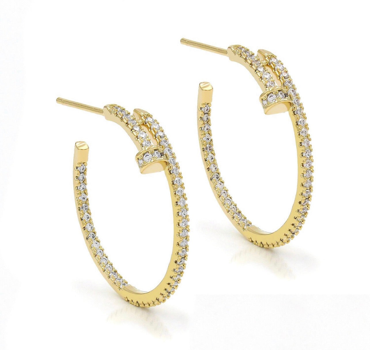 Gold nail pavé hoop earrings on white