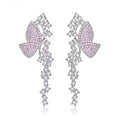 Pink pavé butterfly dangle earrings on a white background