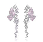 Pink pavé butterfly dangle earrings on a white background
