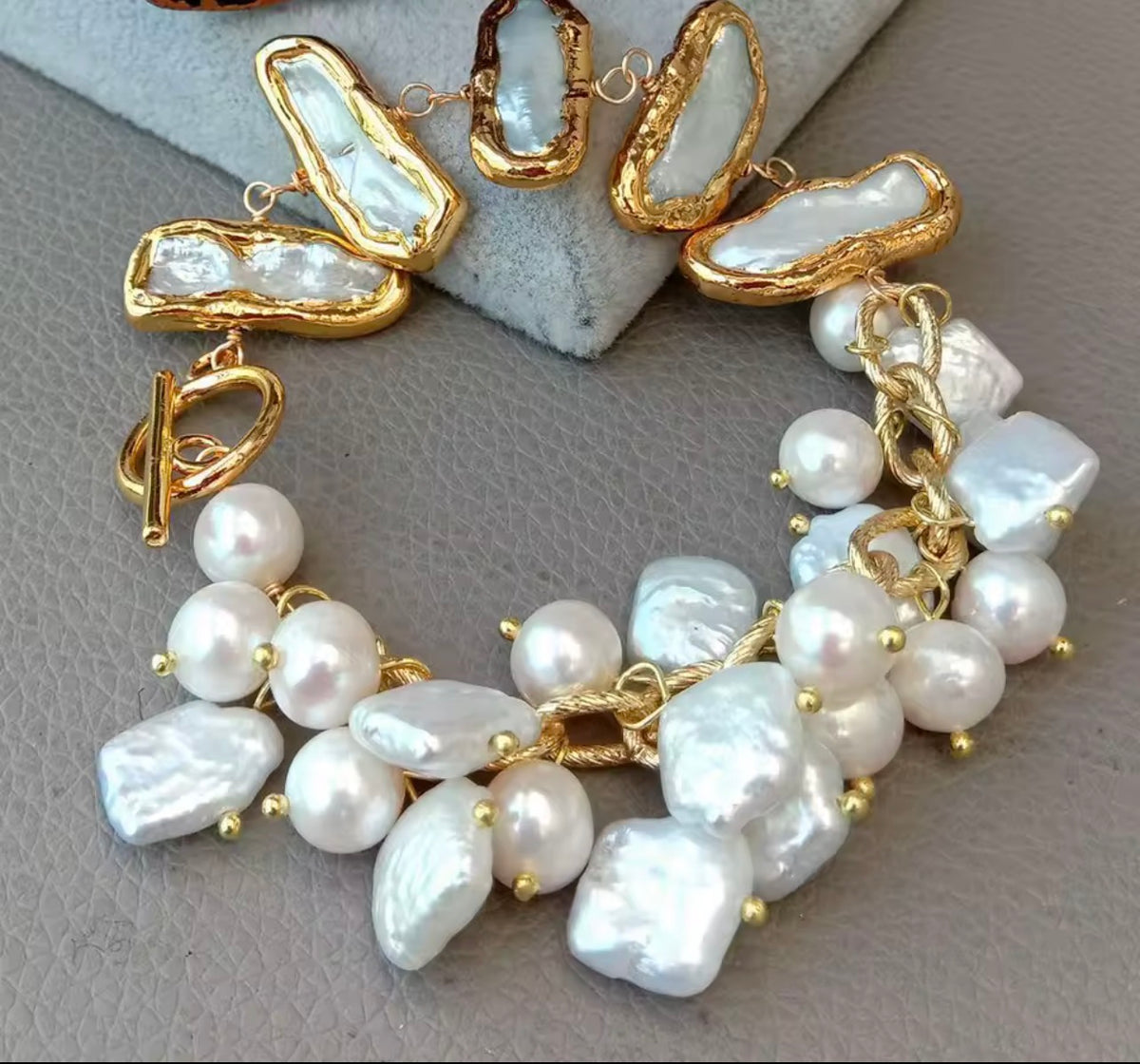 Multi freshwater pearl and gold-plated statement bracelet displayed on a jewelry stand