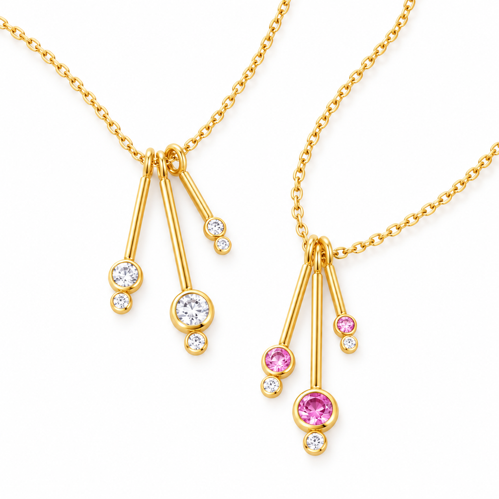Gold dancing teardrop necklaces in clear and pink stones on white background
