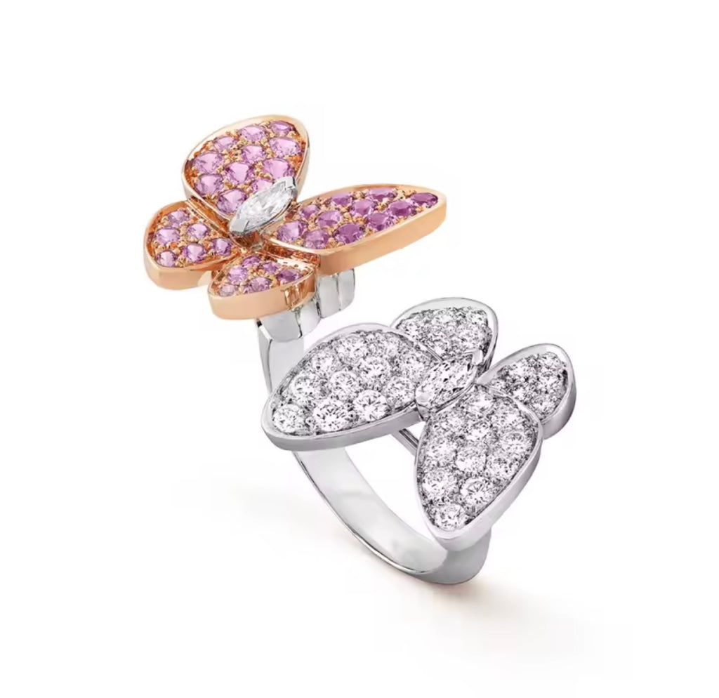Close-up of double butterfly ring in pink and white with gold accents