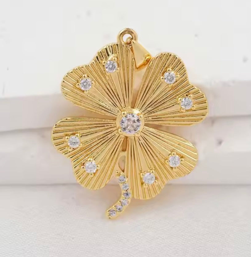 Gold four-leaf clover charm pendant with sparkling clear accents