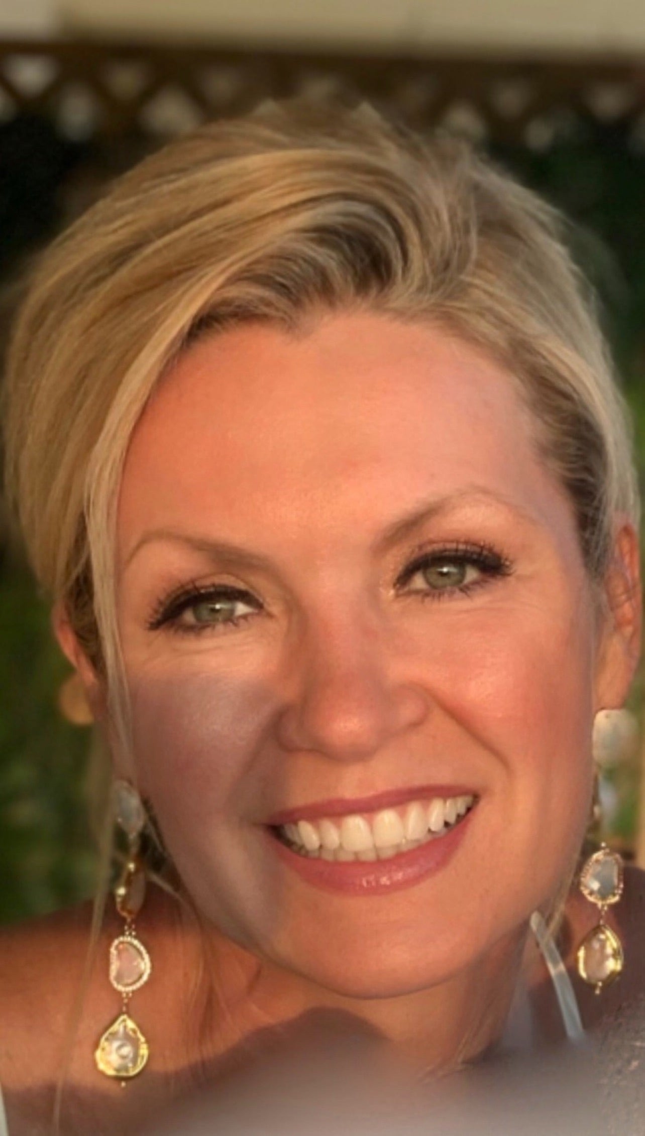 Gold pearl dangle earrings worn by Christine