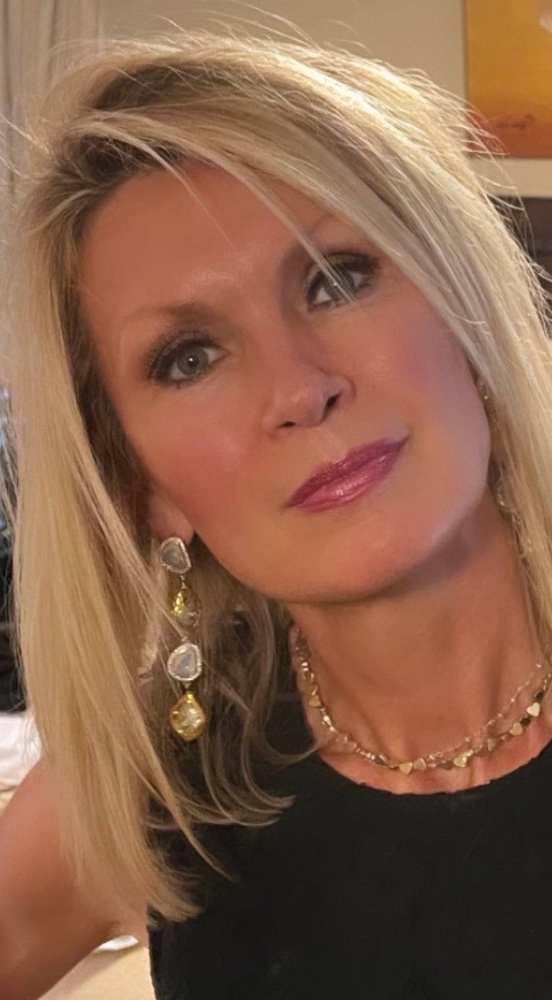 Gold pearl dangle earrings worn by Christine