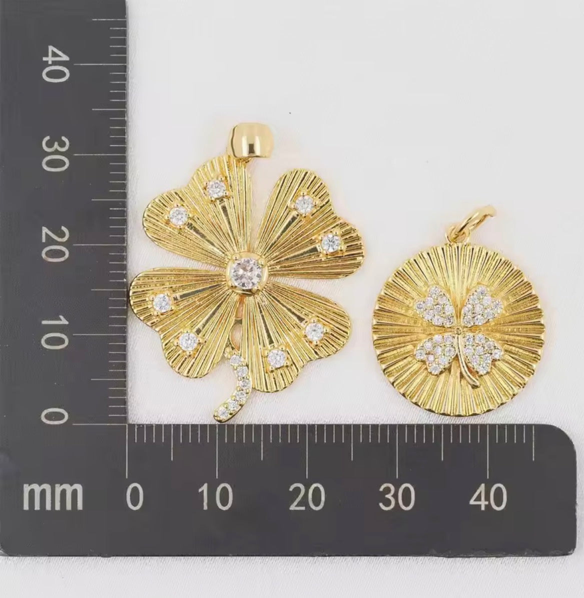 Round gold pendant with four-leaf clover detail