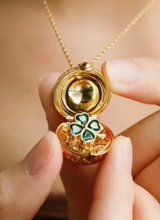 Close-up of the green four-leaf clover inside the gold globe charm