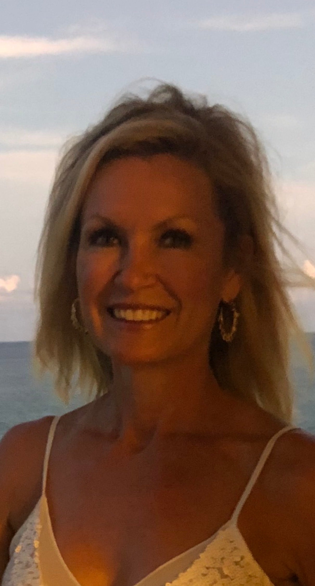 Christine wearing gold teardrop stone hoop earrings