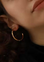 Gold hoop earrings worn on ear