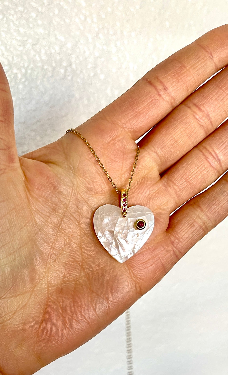 Ruby heart pendant shown in hand
